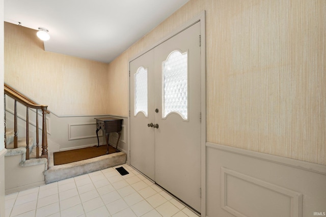 405 Inglenook Pl, Angola, IN 46703 - foyer entrance featuring wallpapered walls, stairs, and a wainscoted wall