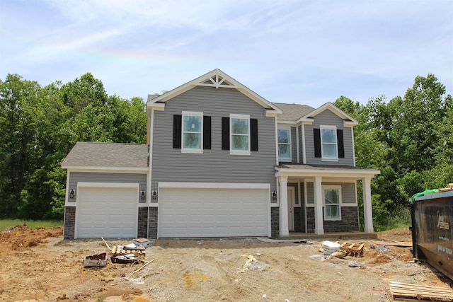 1006 E Brandy Blvd, Ellettsville, IN 47429 - view of front of property featuring stone siding, a shingled roof, driveway, an attached garage, and a porch