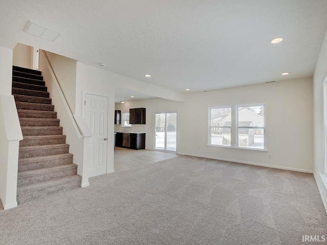 1006 E Brandy Blvd, Ellettsville, IN 47429 - unfurnished living room with light carpet, stairs, baseboards, recessed lighting, and a textured ceiling