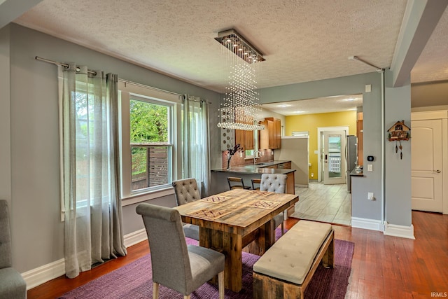 413 Lingle Ave, Lafayette, IN 47901 - dining area featuring baseboards, a textured ceiling, wood finished floors, and a chandelier
