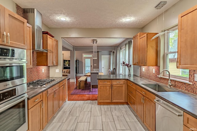 413 Lingle Ave, Lafayette, IN 47901 - kitchen with stainless steel appliances, a sink, a textured ceiling, dark countertops, and tasteful backsplash