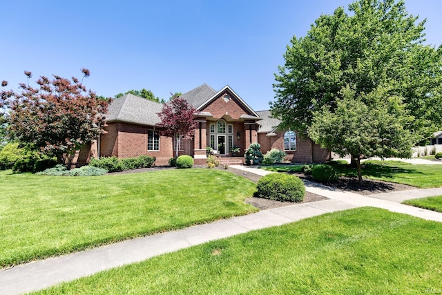 136 Tulip Cir, Bremen, IN 46506 - view of front facade with brick siding, a front lawn, and roof with shingles