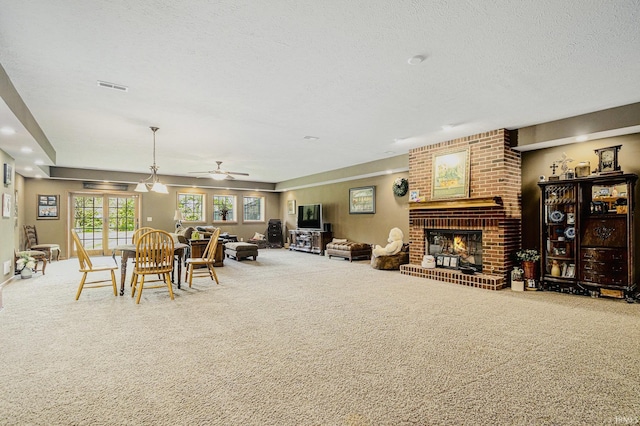 136 Tulip Cir, Bremen, IN 46506 - dining area featuring carpet floors, a fireplace, a ceiling fan, and a textured ceiling