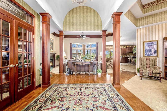 136 Tulip Cir, Bremen, IN 46506 - entryway with decorative columns, lofted ceiling, wood finished floors, a ceiling fan, and a warm lit fireplace