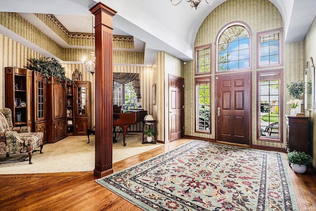 136 Tulip Cir, Bremen, IN 46506 - entrance foyer featuring ornate columns, high vaulted ceiling, wood finished floors, and healthy amount of natural light