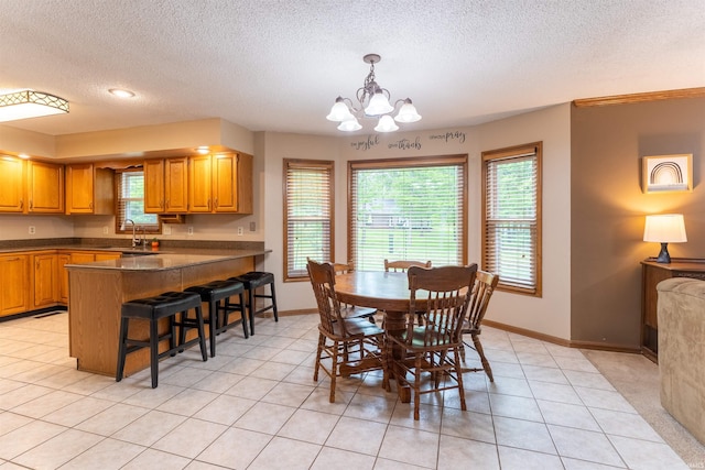 620 Bob Ct, Evansville, IN 47711 - dining area with a textured ceiling, baseboards, a chandelier, and light tile patterned floors