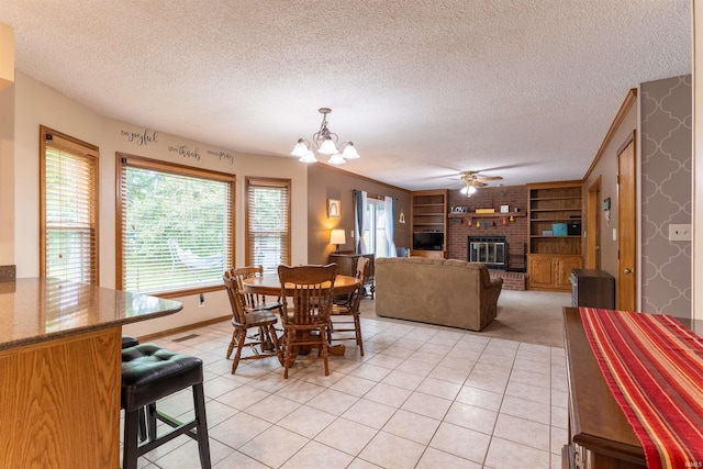 620 Bob Ct, Evansville, IN 47711 - dining space featuring a textured ceiling, a chandelier, a fireplace, a ceiling fan, and built in shelves