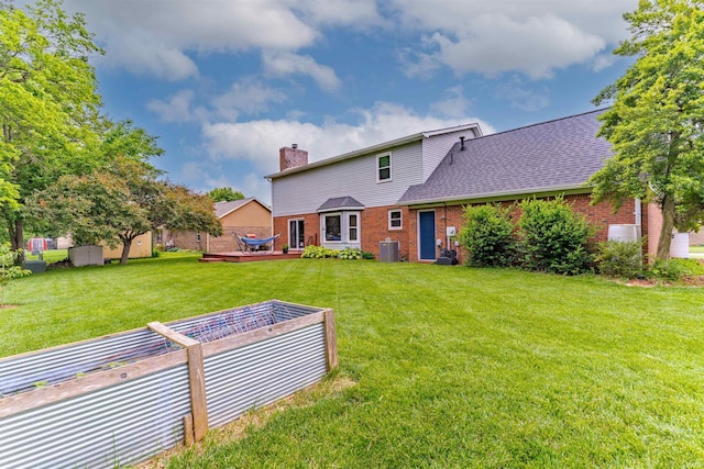 620 Bob Ct, Evansville, IN 47711 - rear view of house featuring a vegetable garden, a chimney, a lawn, and brick siding