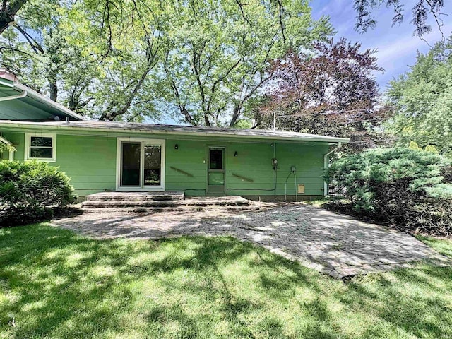 141 Indian Rock Dr, West Lafayette, IN 47906 - back of house featuring a lawn and a patio