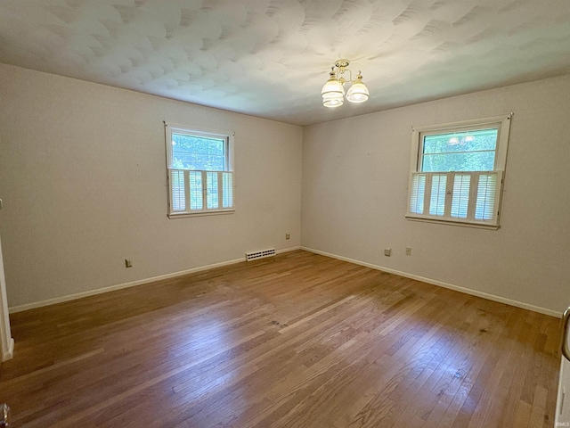 141 Indian Rock Dr, West Lafayette, IN 47906 - empty room with wood finished floors, a chandelier, and baseboards