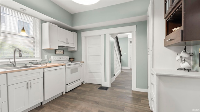 1018 Loree St, Fort Wayne, IN 46805 - kitchen featuring white appliances, under cabinet range hood, dark wood finished floors, a sink, and white cabinetry