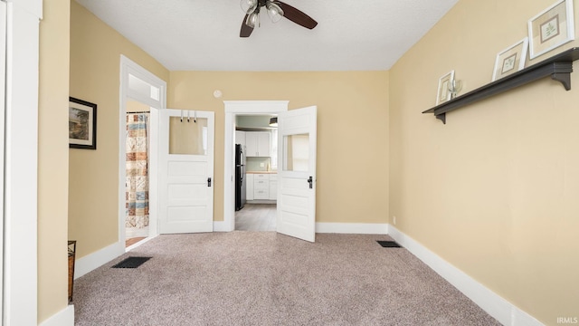 1018 Loree St, Fort Wayne, IN 46805 - unfurnished bedroom featuring carpet, freestanding refrigerator, baseboards, connected bathroom, and a ceiling fan