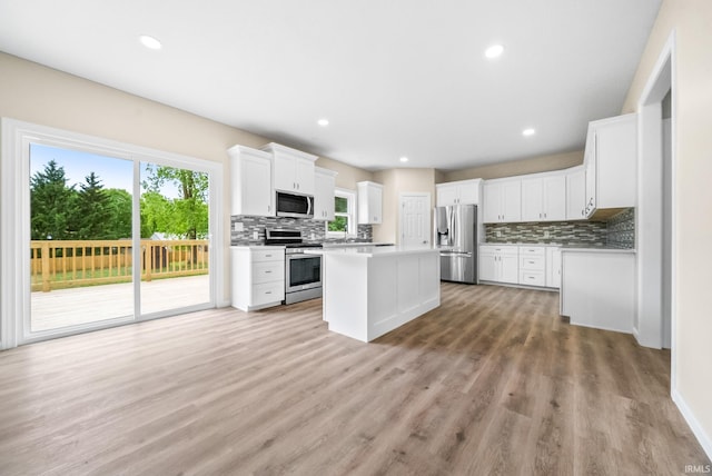 2416 S Woodland Trl, Warsaw, IN 46580 - kitchen with stainless steel appliances, decorative backsplash, a center island, light wood finished floors, and recessed lighting