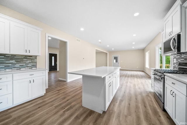 2416 S Woodland Trl, Warsaw, IN 46580 - kitchen featuring appliances with stainless steel finishes, decorative backsplash, light wood finished floors, white cabinetry, and light countertops