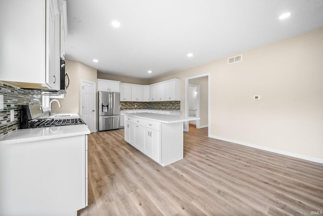 2416 S Woodland Trl, Warsaw, IN 46580 - kitchen featuring stainless steel appliances, tasteful backsplash, white cabinets, light countertops, and recessed lighting