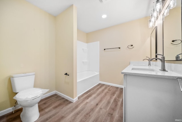 2416 S Woodland Trl, Warsaw, IN 46580 - bathroom with toilet, baseboards, double vanity, and wood finished floors