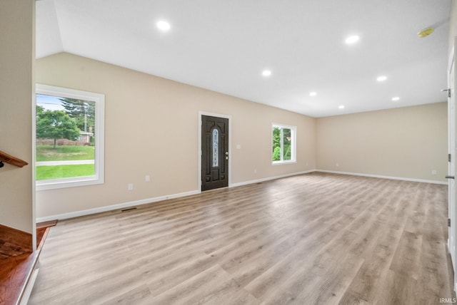 2416 S Woodland Trl, Warsaw, IN 46580 - unfurnished living room with light wood-style floors, recessed lighting, baseboards, and lofted ceiling