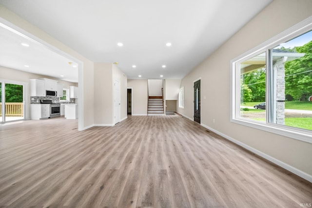 2416 S Woodland Trl, Warsaw, IN 46580 - unfurnished living room featuring healthy amount of natural light, baseboards, light wood-style floors, and recessed lighting