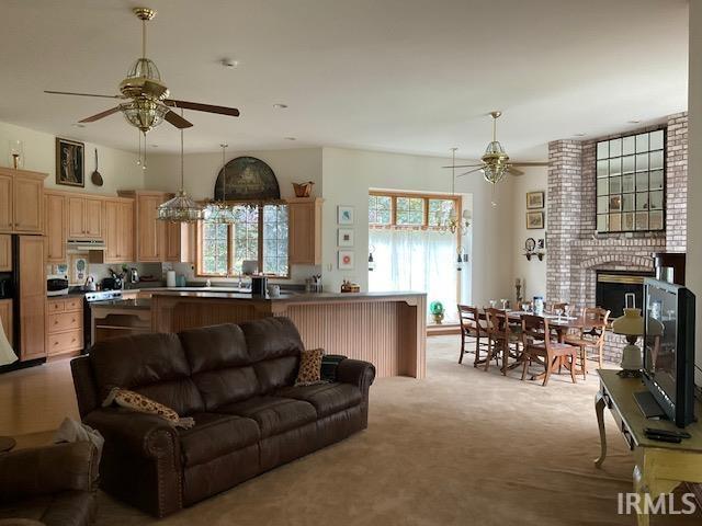 10872 N 875 E, Otterbein, IN 47970 - carpeted living area featuring ceiling fan and a fireplace with raised hearth