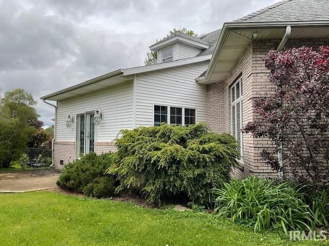 10872 N 875 E, Otterbein, IN 47970 - view of property exterior featuring brick siding, a patio area, a yard, and roof with shingles