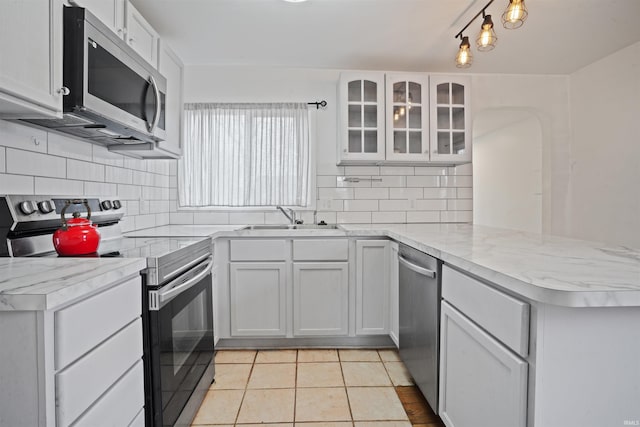 123 S Race St, Princeton, IN 47670 - kitchen featuring stainless steel appliances, a sink, a peninsula, decorative backsplash, and white cabinetry