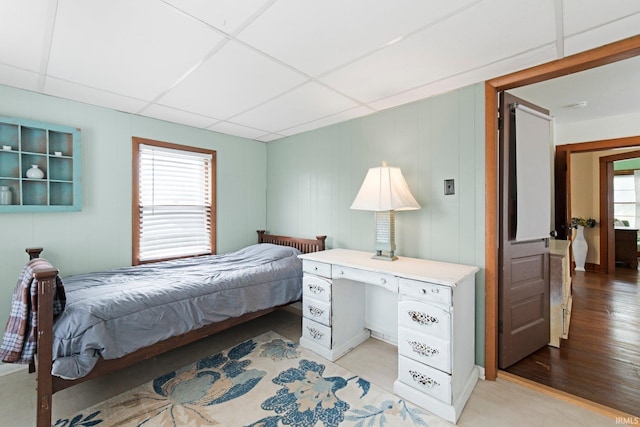 4325 S Wayne Ave, Fort Wayne, IN 46807 - bedroom featuring a drop ceiling, light wood-style flooring, and a decorative wall