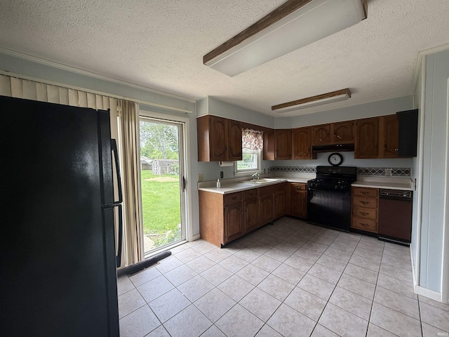 205 Riley Blvd, Bedford, IN 47421 - kitchen featuring black appliances, a textured ceiling, light countertops, under cabinet range hood, and light tile patterned floors