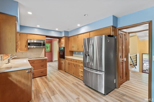 2730 Newman Rd, West Lafayette, IN 47906 - kitchen featuring appliances with stainless steel finishes, light wood finished floors, light countertops, a sink, and recessed lighting