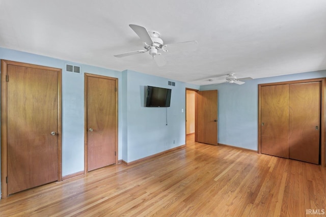 2730 Newman Rd, West Lafayette, IN 47906 - unfurnished bedroom with two closets, baseboards, light wood-style floors, and a ceiling fan