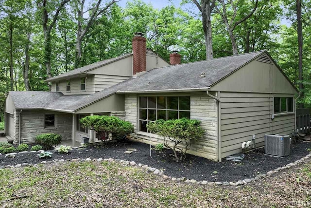 2730 Newman Rd, West Lafayette, IN 47906 - view of side of home featuring a chimney, stone siding, a shingled roof, and central air condition unit