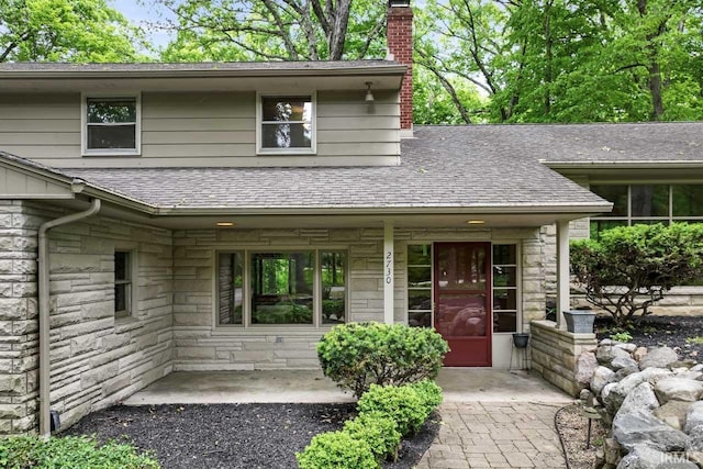 2730 Newman Rd, West Lafayette, IN 47906 - view of front of house featuring a chimney, a shingled roof, and stone siding