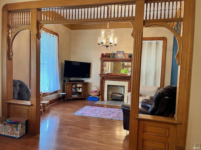 35 W Pine St, Knightstown, IN 46148 - living room with wood finished floors, a chandelier, a fireplace with flush hearth, and baseboards