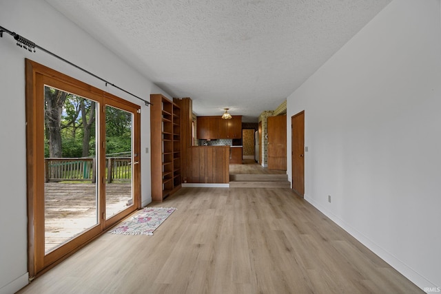 3301 Cedar Ln, Lafayette, IN 47905 - unfurnished living room with light wood-style flooring, a textured ceiling, and baseboards