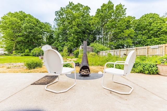 6607 W Ryan Dr, Anderson, IN 46011 - view of patio with an outdoor fire pit and view of wooded area