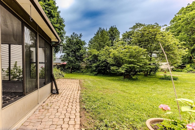 6607 W Ryan Dr, Anderson, IN 46011 - view of grassy yard featuring a sunroom and view of wooded area