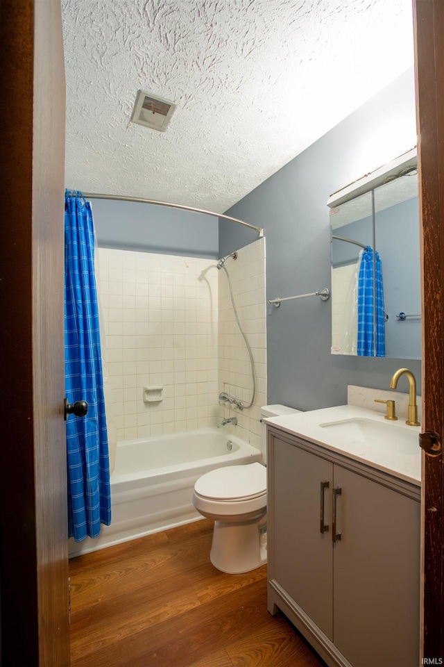 1708 Mason Dixon Dr, West Lafayette, IN 47906 - full bathroom featuring shower / bath combination with curtain, vanity, a textured ceiling, toilet, and wood finished floors