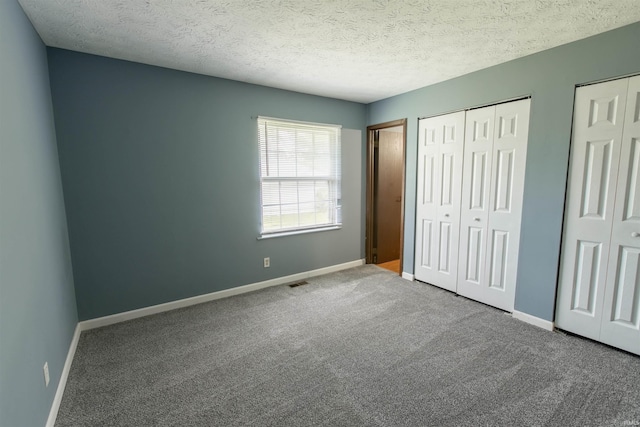 1708 Mason Dixon Dr, West Lafayette, IN 47906 - unfurnished bedroom featuring multiple closets, carpet floors, baseboards, and a textured ceiling