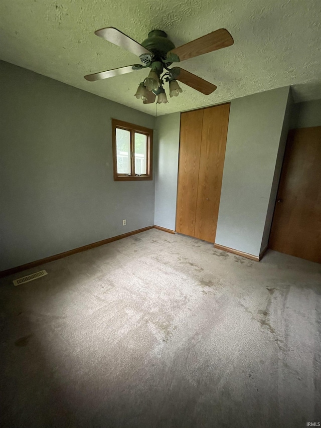 2724 Elva Dr, Kokomo, IN 46902 - unfurnished bedroom featuring light carpet, a closet, a textured ceiling, baseboards, and a ceiling fan