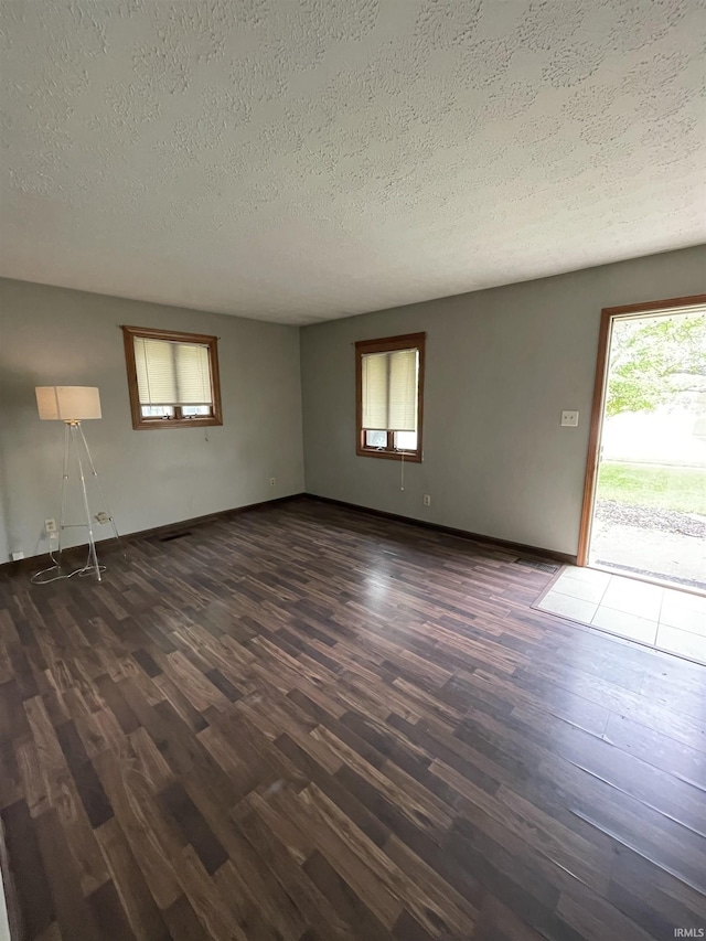 2724 Elva Dr, Kokomo, IN 46902 - empty room featuring dark wood finished floors, a textured ceiling, and baseboards