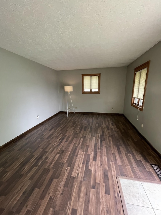 2724 Elva Dr, Kokomo, IN 46902 - spare room with dark wood-type flooring, a textured ceiling, and baseboards