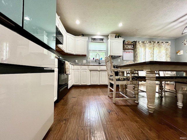 348 N Dover Clfs, Ellettsville, IN 47429 - kitchen with fridge, white cabinetry, a textured ceiling, dark wood-type flooring, and a sink