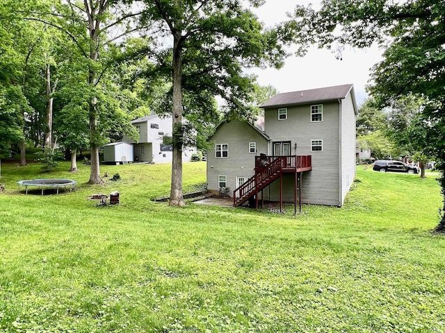 348 N Dover Clfs, Ellettsville, IN 47429 - back of property with a trampoline, stairs, a wooden deck, and a lawn