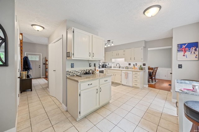 2218 Wake Robin Dr, West Lafayette, IN 47906 - kitchen featuring white dishwasher, light countertops, a textured ceiling, light tile patterned flooring, and white cabinets