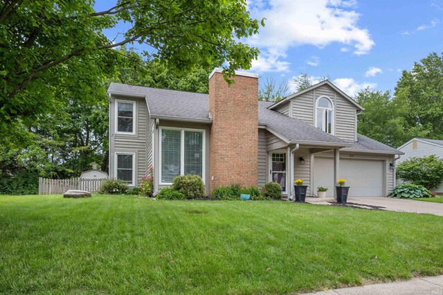 2218 Wake Robin Dr, West Lafayette, IN 47906 - view of front facade featuring a chimney, concrete driveway, a shingled roof, and an attached garage