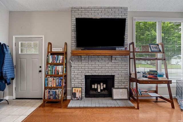 2218 Wake Robin Dr, West Lafayette, IN 47906 - living area with a textured ceiling, a brick fireplace, baseboards, and tile patterned flooring
