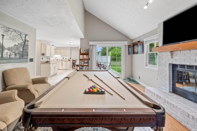 2218 Wake Robin Dr, West Lafayette, IN 47906 - rec room with billiards, a textured ceiling, a brick fireplace, lofted ceiling, and a sink