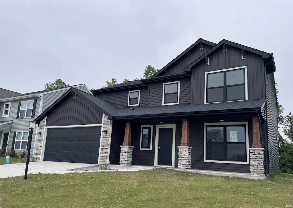 14778 Verona Lakes Psge, Fort Wayne, IN 46814 - view of front of house with covered porch, an attached garage, board and batten siding, stone siding, and a front yard