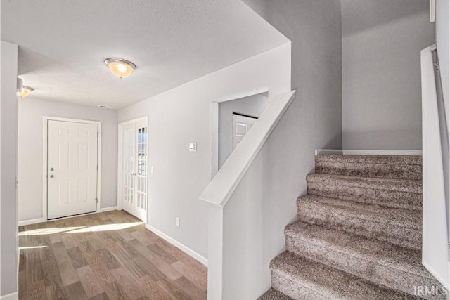 8247 Catberry Trl, Fort Wayne, IN 46804 - foyer entrance with wood finished floors, stairway, and baseboards