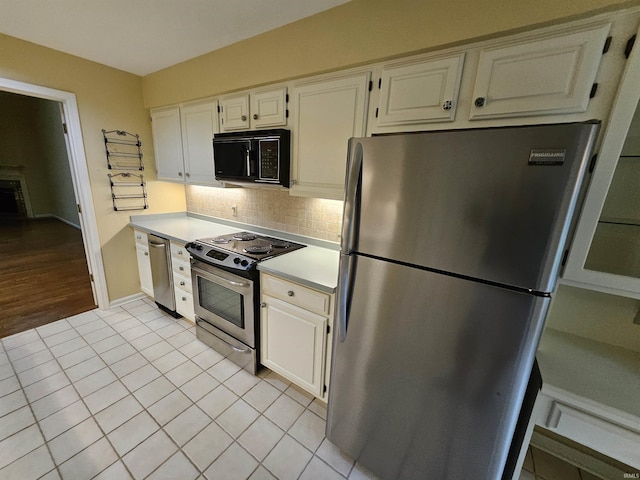 1327 Timberlake Rd, Evansville, IN 47710 - kitchen featuring appliances with stainless steel finishes, decorative backsplash, light countertops, light tile patterned floors, and white cabinetry