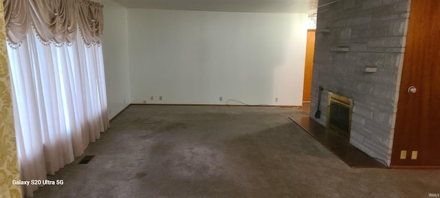 1202 N Sheridan Rd, Marion, IN 46952 - unfurnished living room featuring carpet flooring, a stone fireplace, and baseboards